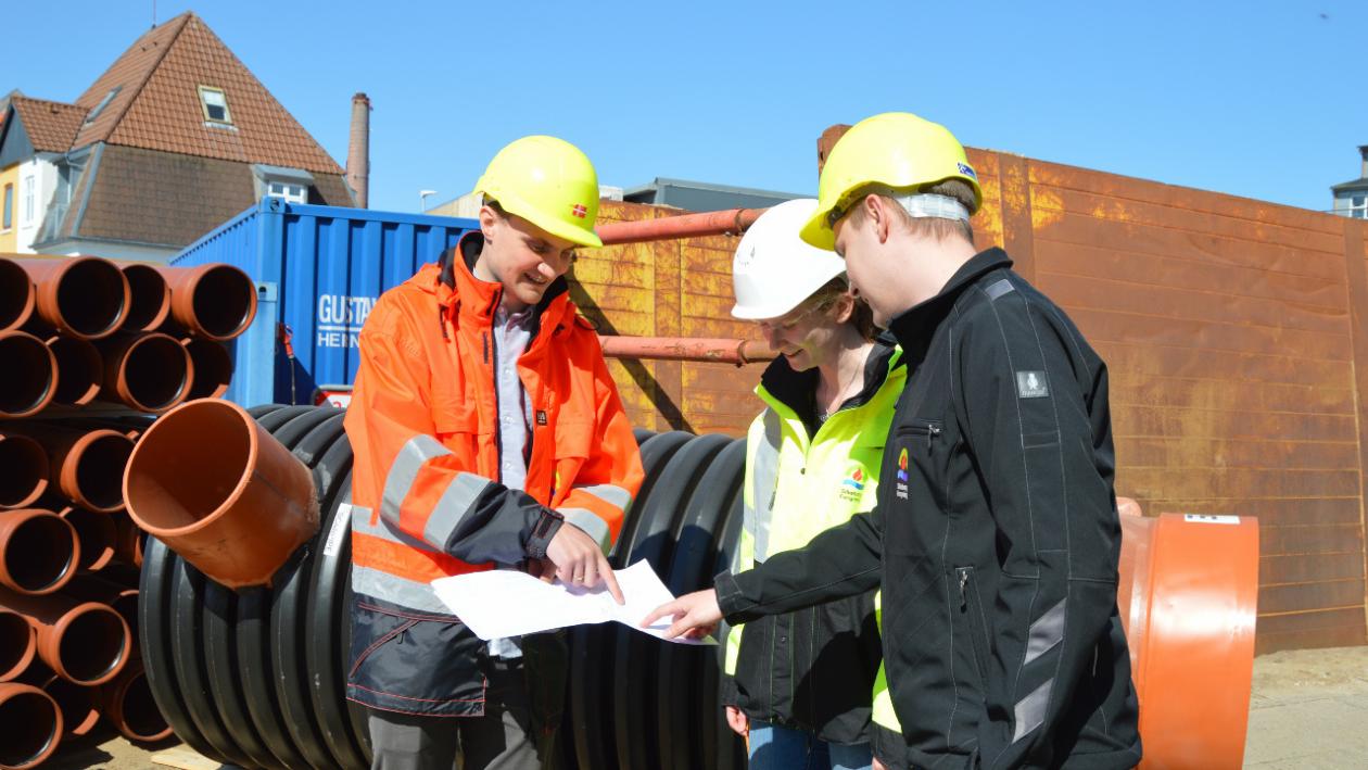 Medarbejdere hos Silkeborg Forsyning står og kigger på et kort ved kloakprojekt